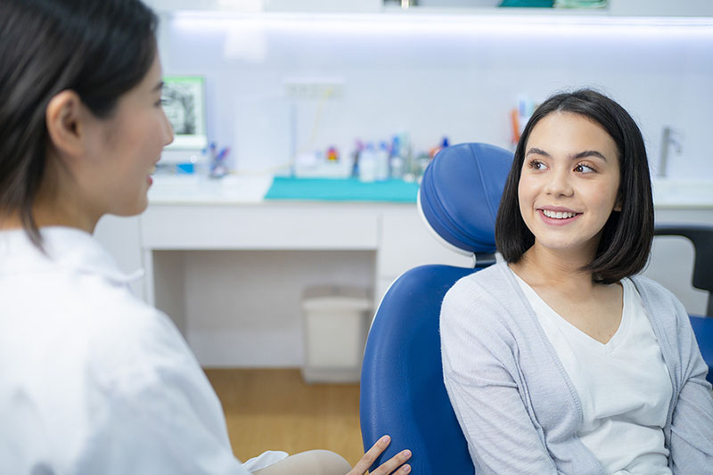 dentist talks to patient about dental fillings