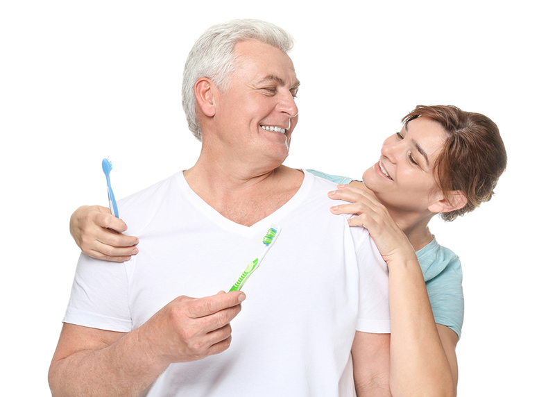 older man and woman brushing their teeth oral hygiene routine
