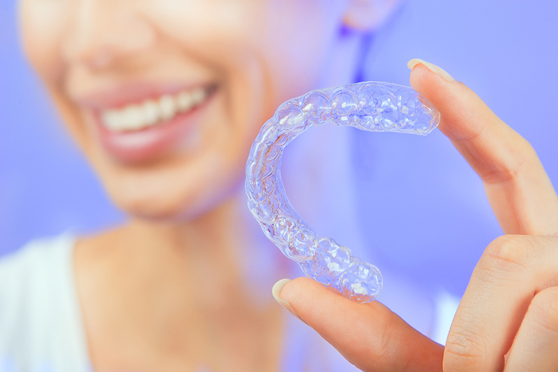woman holding at-home teeth whitening tray
