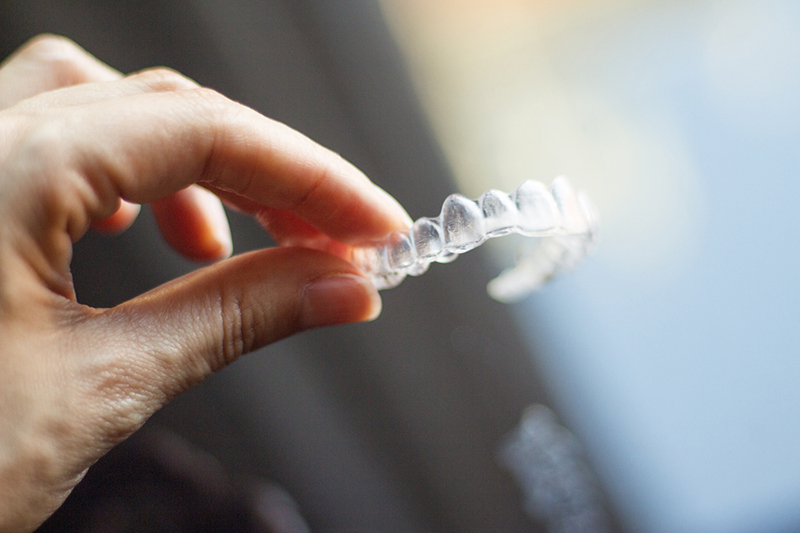 woman holding 3-d printed dental aligner